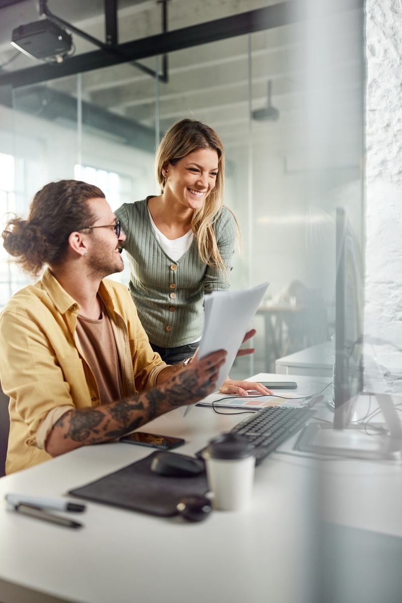 a man and woman looking at a computer