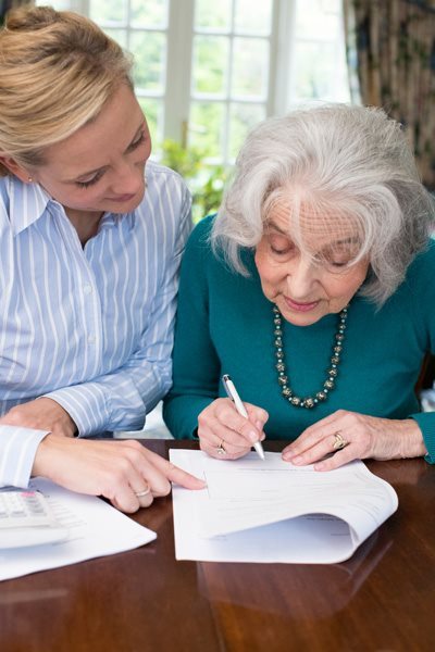 An advisor helping an elderly client with a document
